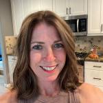 Picture of a smiling female with medium length brown hair.